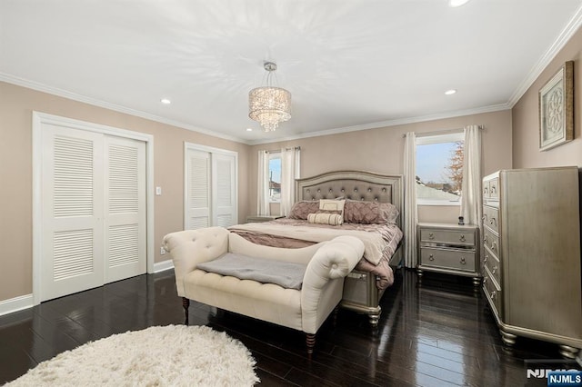 bedroom with baseboards, multiple closets, dark wood-style floors, and crown molding