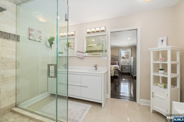 bathroom featuring tile patterned floors, a stall shower, connected bathroom, baseboards, and vanity