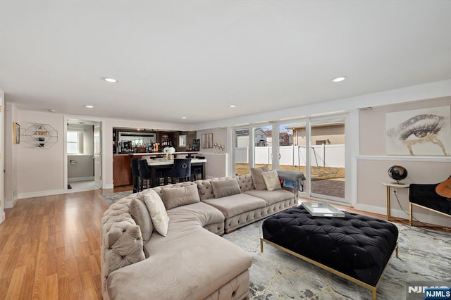 living room featuring recessed lighting, light wood-type flooring, and baseboards