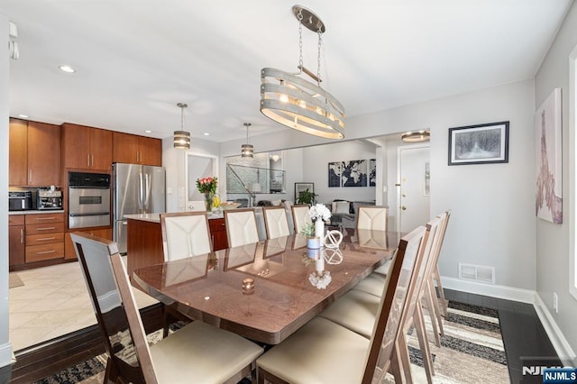 dining room featuring light tile patterned floors, visible vents, baseboards, recessed lighting, and a chandelier