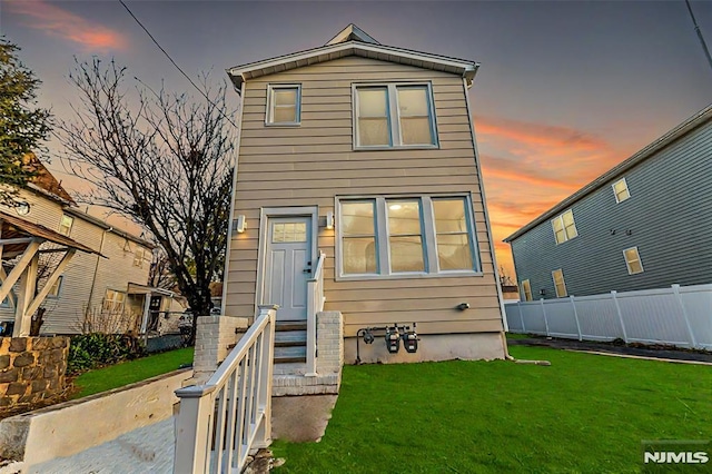 view of front of property featuring fence and a front lawn