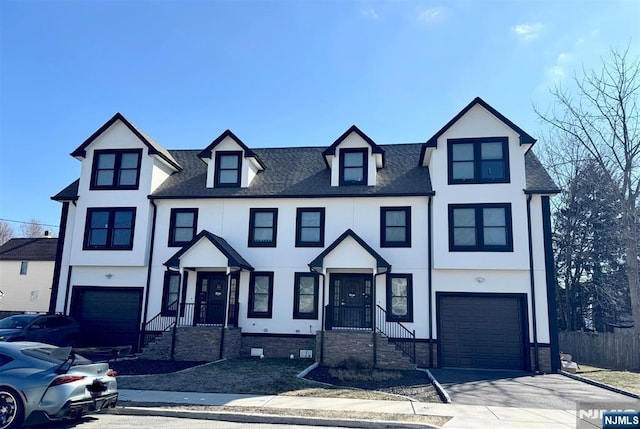 townhome / multi-family property with concrete driveway, roof with shingles, an attached garage, and stucco siding