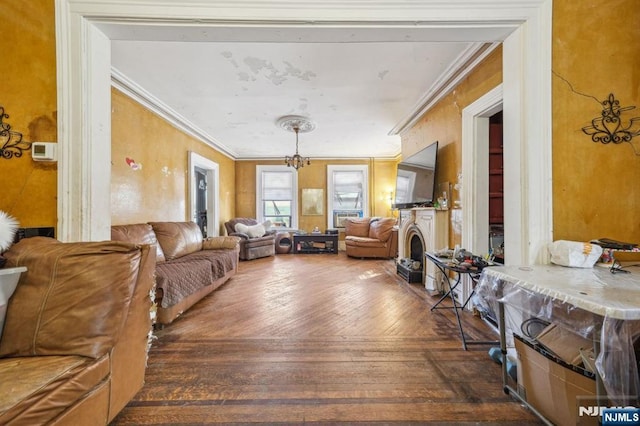 living area with a notable chandelier, a fireplace, crown molding, and hardwood / wood-style floors