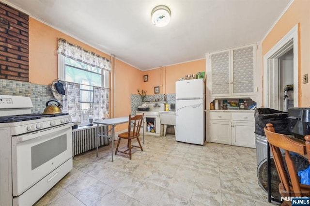 kitchen featuring decorative backsplash, white appliances, white cabinetry, and radiator heating unit