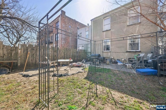 rear view of property featuring a patio and fence