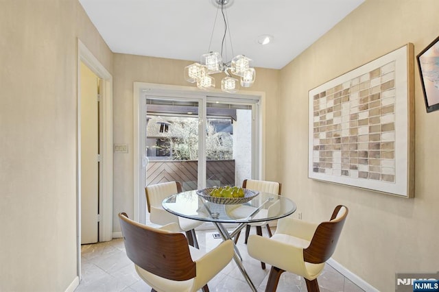 dining space with an inviting chandelier and baseboards