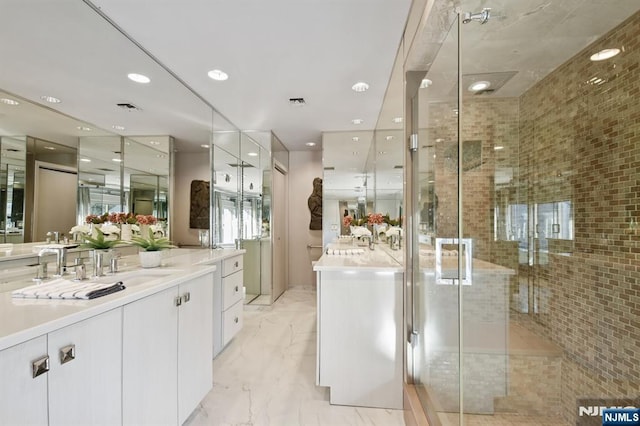 bathroom featuring marble finish floor, vanity, a shower stall, and visible vents