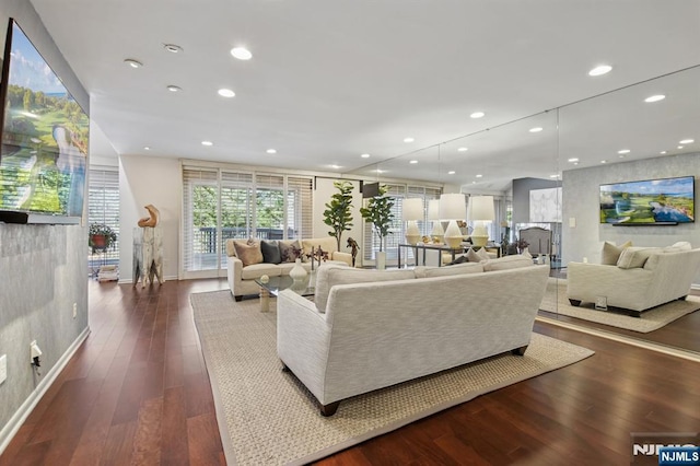 living room with dark wood-type flooring and recessed lighting