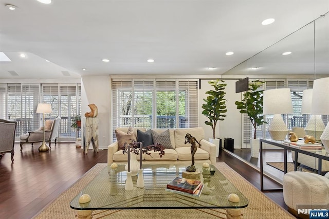 living area featuring a healthy amount of sunlight, baseboards, wood finished floors, and recessed lighting