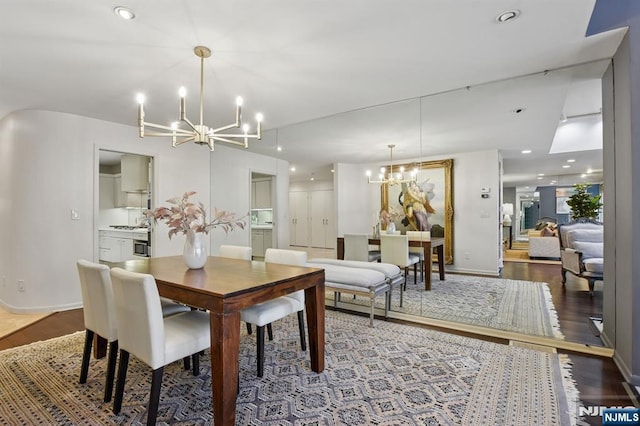 dining area featuring recessed lighting, wood finished floors, and an inviting chandelier