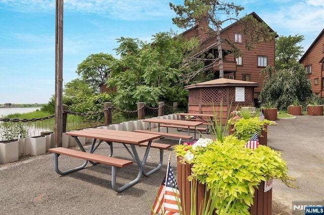 balcony with outdoor dining space, a patio, and a water view