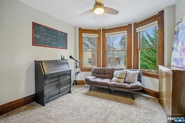 sitting room with carpet, ceiling fan, and baseboards