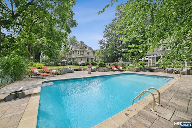 outdoor pool with a patio area