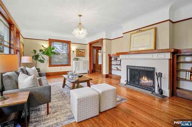 living room featuring a fireplace with flush hearth, wood finished floors, and baseboards