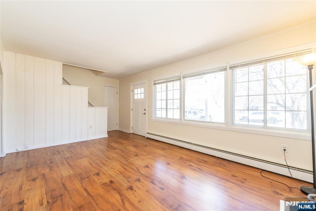 interior space with baseboard heating and wood finished floors