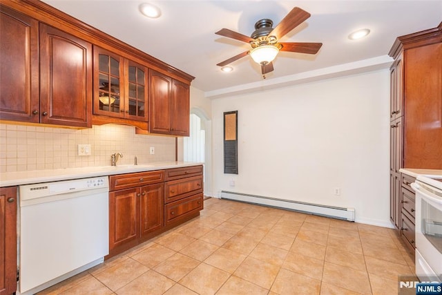 kitchen featuring white appliances, light countertops, baseboard heating, and a sink