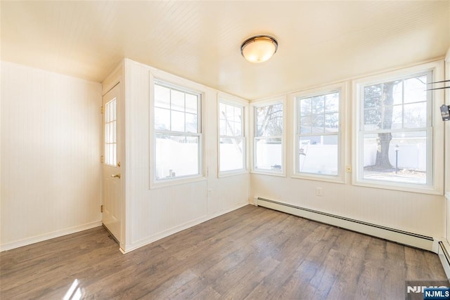 unfurnished sunroom featuring a baseboard heating unit