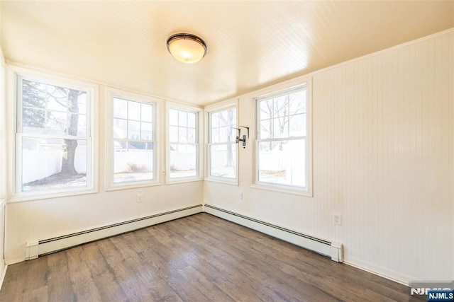 unfurnished sunroom with a baseboard heating unit