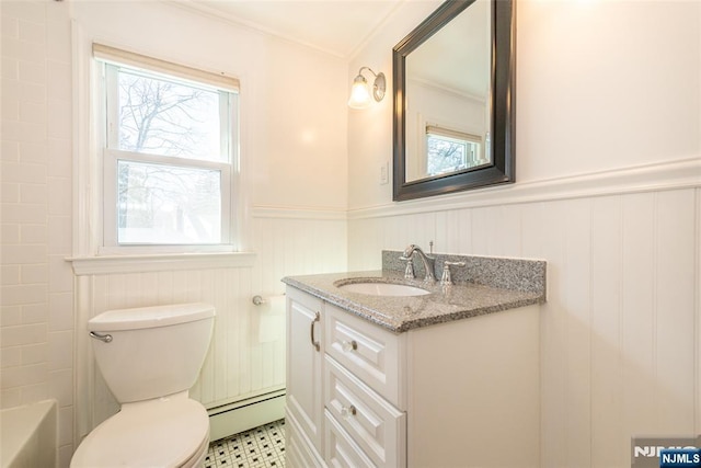 bathroom with vanity, a bathing tub, a baseboard radiator, wainscoting, and toilet