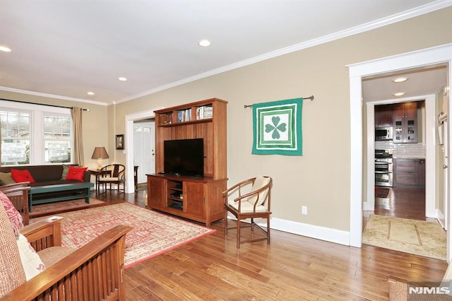 living area with ornamental molding, light wood finished floors, recessed lighting, and baseboards