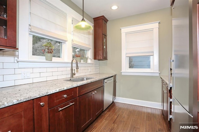 kitchen featuring tasteful backsplash, glass insert cabinets, stainless steel appliances, and a sink