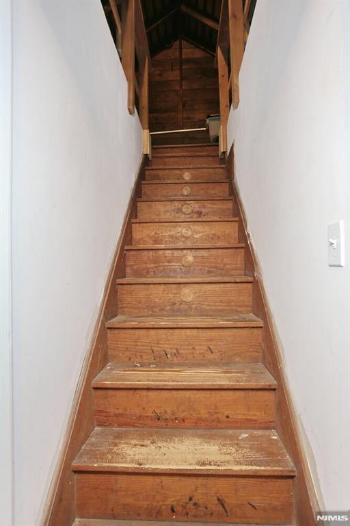 stairs with vaulted ceiling and hardwood / wood-style floors