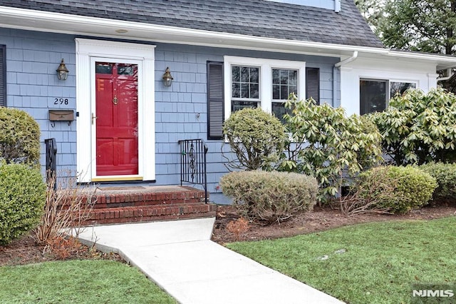 entrance to property with roof with shingles