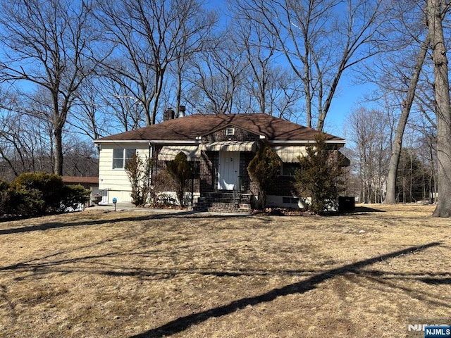 view of front of home featuring brick siding and a chimney