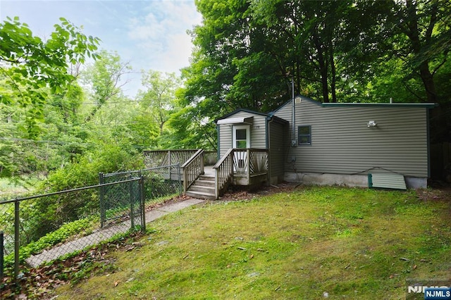 exterior space with a front yard, fence, and a wooden deck