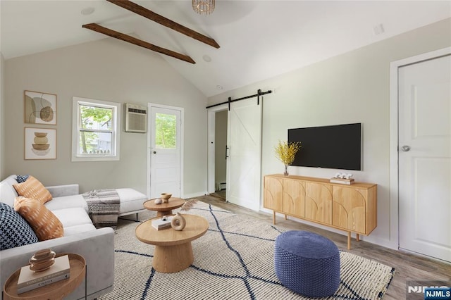 living area featuring lofted ceiling with beams, light wood-style floors, a barn door, and a wall mounted AC