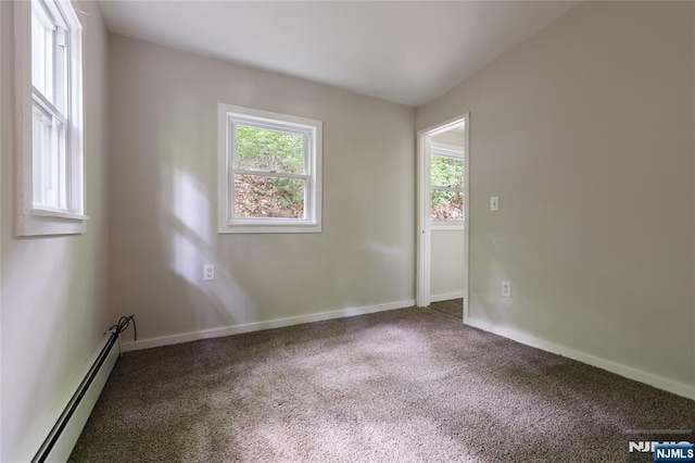 carpeted spare room with a baseboard radiator and baseboards