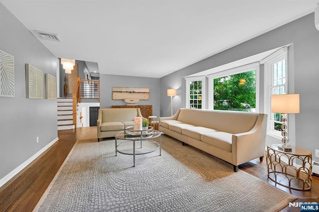 living area featuring stairs, wood finished floors, visible vents, and baseboards