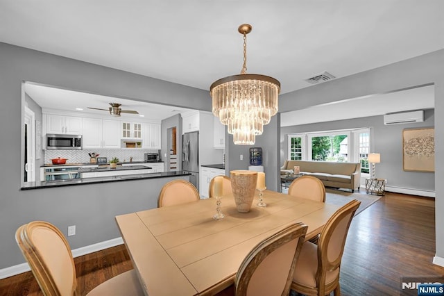 dining space featuring dark wood-type flooring, a wall mounted air conditioner, baseboards, and ceiling fan with notable chandelier