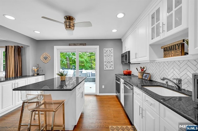 kitchen with a healthy amount of sunlight, appliances with stainless steel finishes, a sink, and wood finished floors