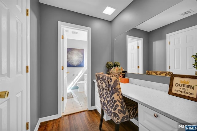 full bath with baseboards, visible vents, a freestanding bath, and wood finished floors