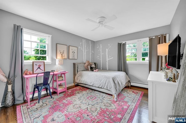 bedroom featuring a baseboard heating unit, wood finished floors, a ceiling fan, and baseboards