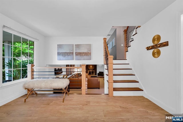 sitting room with stairs, wood finished floors, and baseboards