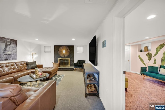 living area featuring recessed lighting, carpet, and a brick fireplace