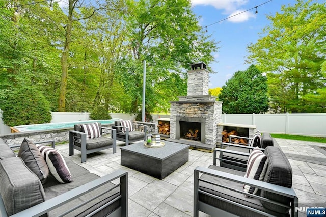 view of patio featuring a fenced backyard, an outdoor pool, and an outdoor living space with a fireplace