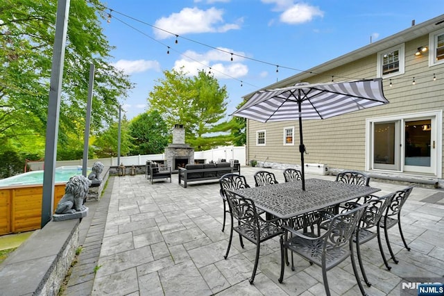 view of patio featuring an outdoor living space with a fireplace, fence, and outdoor dining area