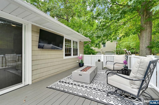 deck featuring an outdoor living space with a fire pit