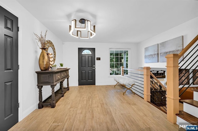 entrance foyer featuring stairs, baseboards, and wood finished floors