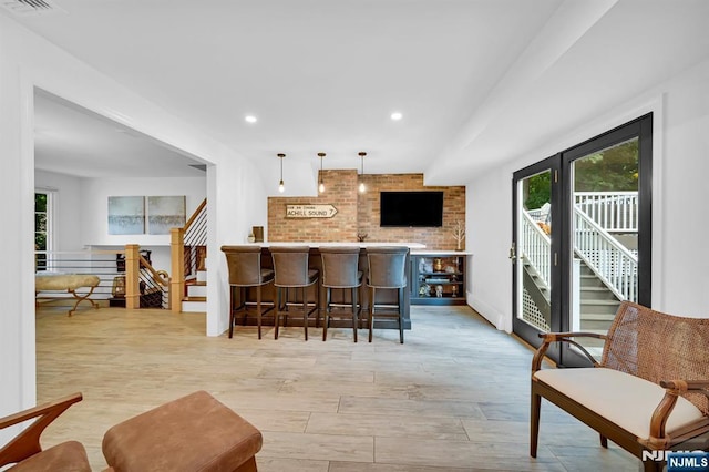 kitchen featuring a breakfast bar, pendant lighting, recessed lighting, light wood-style floors, and a peninsula