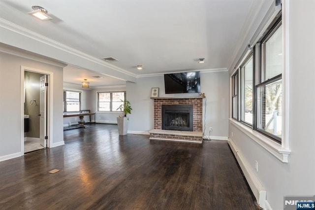 unfurnished living room featuring dark wood finished floors, crown molding, a fireplace, visible vents, and baseboards