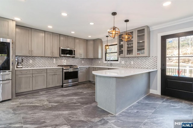 kitchen with decorative backsplash, glass insert cabinets, appliances with stainless steel finishes, a peninsula, and gray cabinets