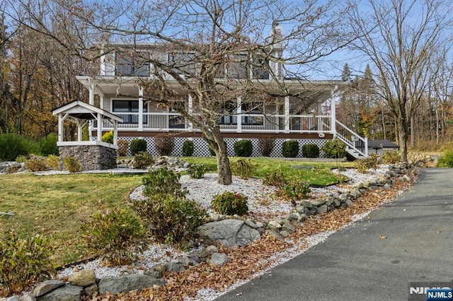 farmhouse featuring stairs and a front yard