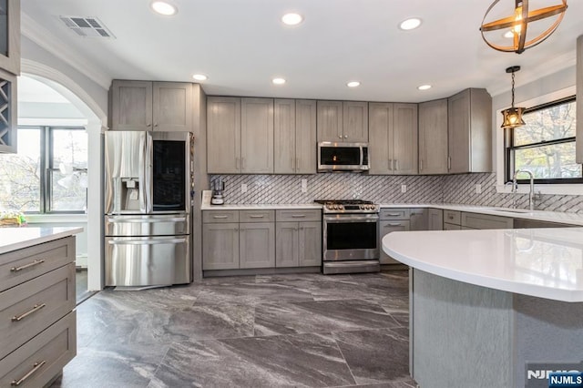 kitchen featuring visible vents, a sink, gray cabinets, stainless steel appliances, and backsplash