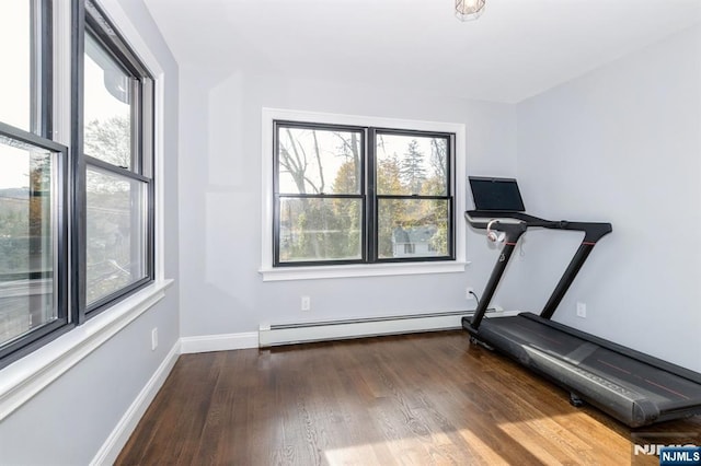 exercise room with a baseboard radiator, baseboards, and wood finished floors