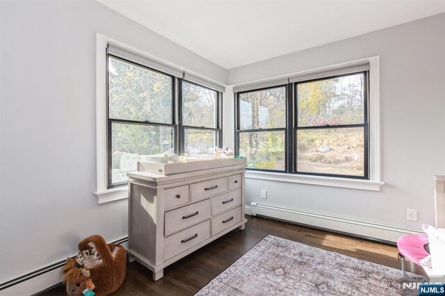 bedroom featuring dark wood-style flooring and baseboard heating