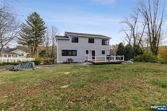 back of property featuring a yard and a wooden deck